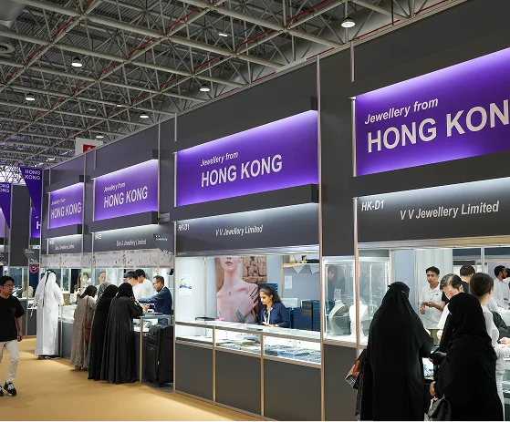 A diverse group of people browses a jewelry display in a retail store, surrounded by an array of shopping options.